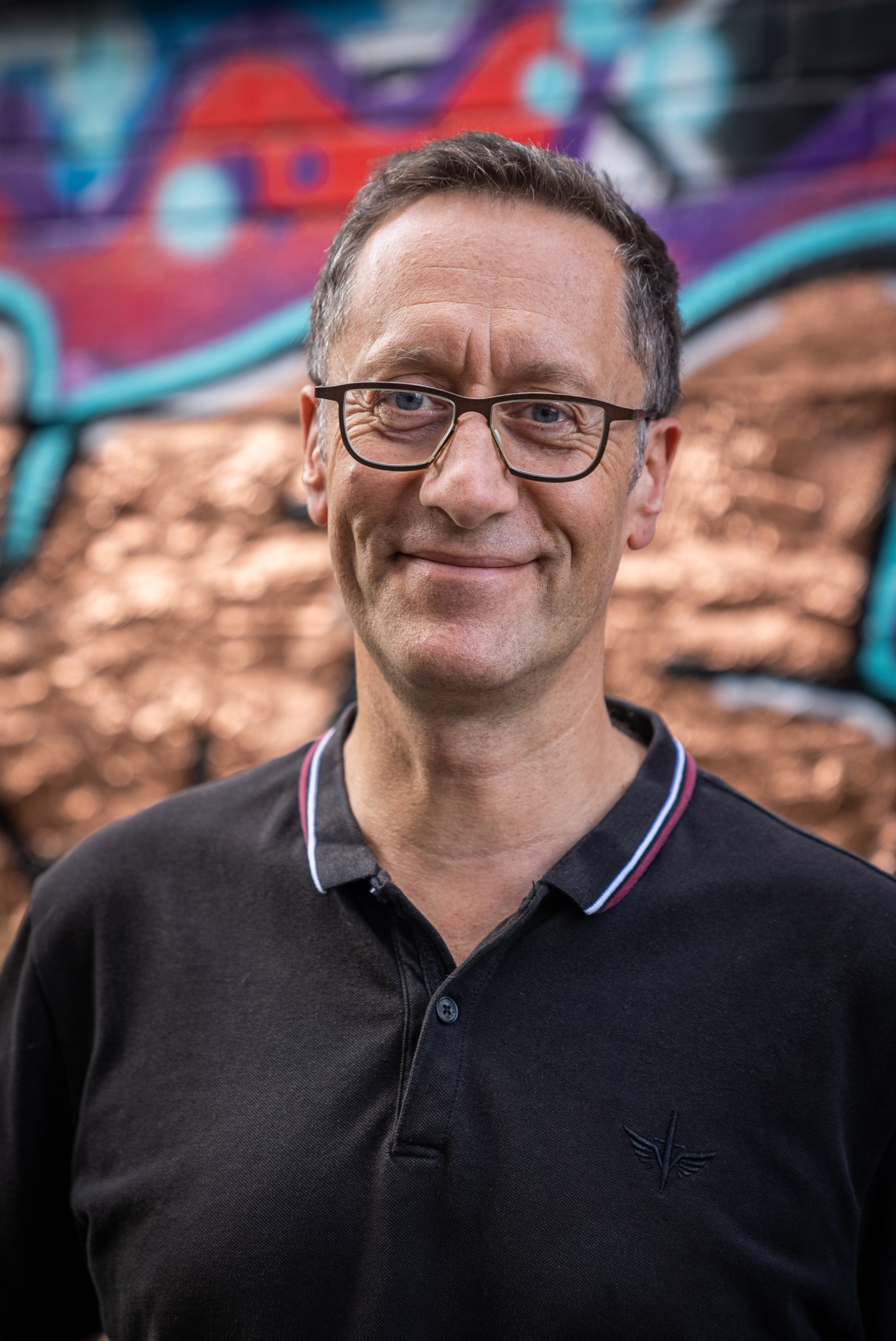 Hamish Beeston standing in front of street art. Beeston Media video production bristol science and technology video production higher education video production