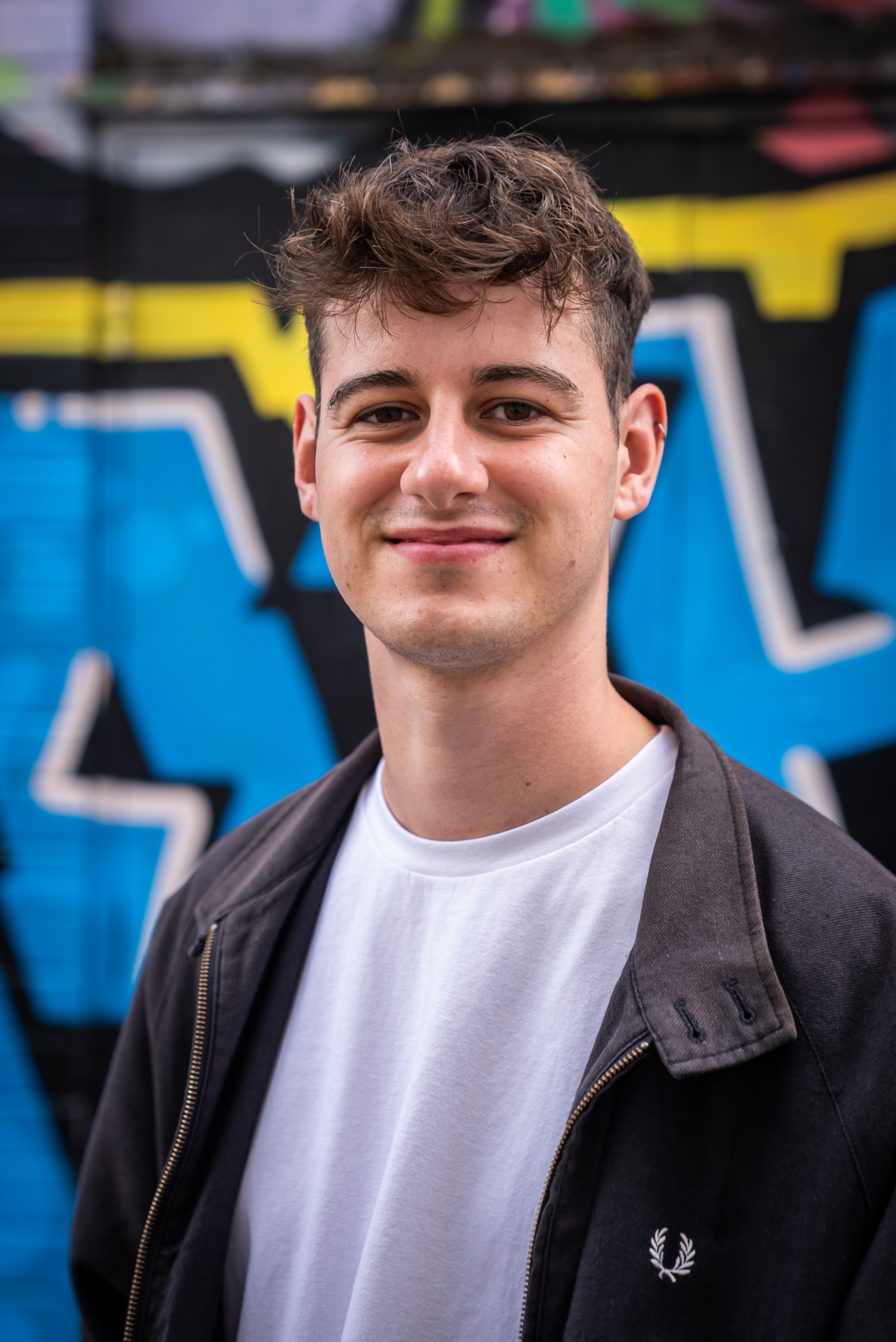 Joe Astill in front of street art. Beeston Media video production bristol science and technology video production higher education video production.