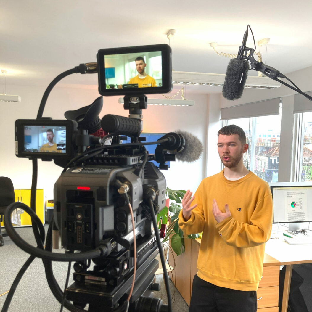 Camera filming contributor in office. Beeston Media video production bristol science and technology video production higher education video production.